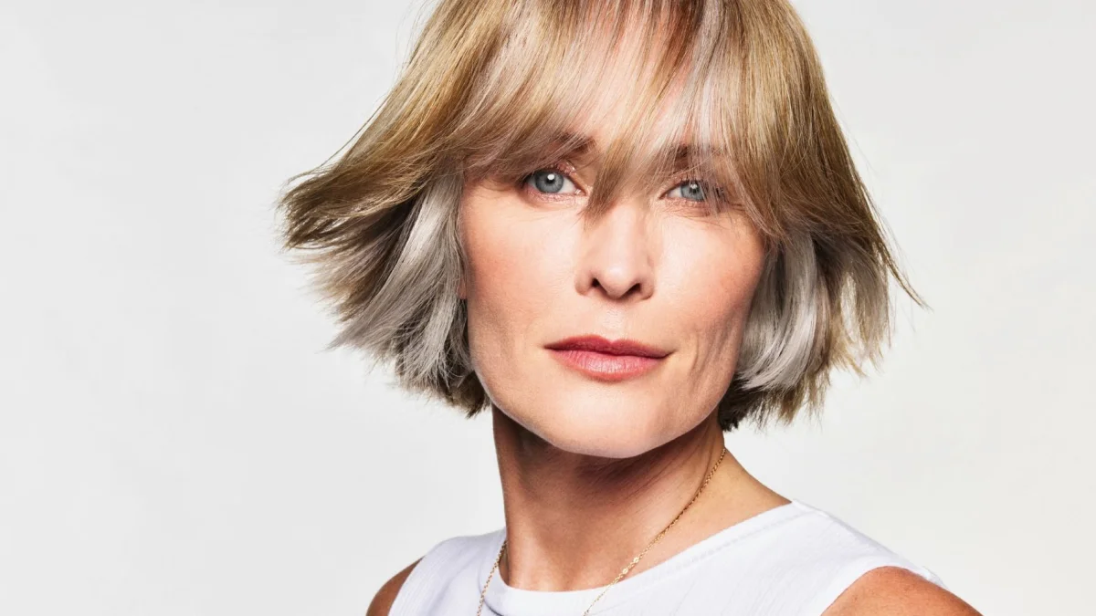 Close-up van een model met een blonde bob, luchtige lagen en een lange pony