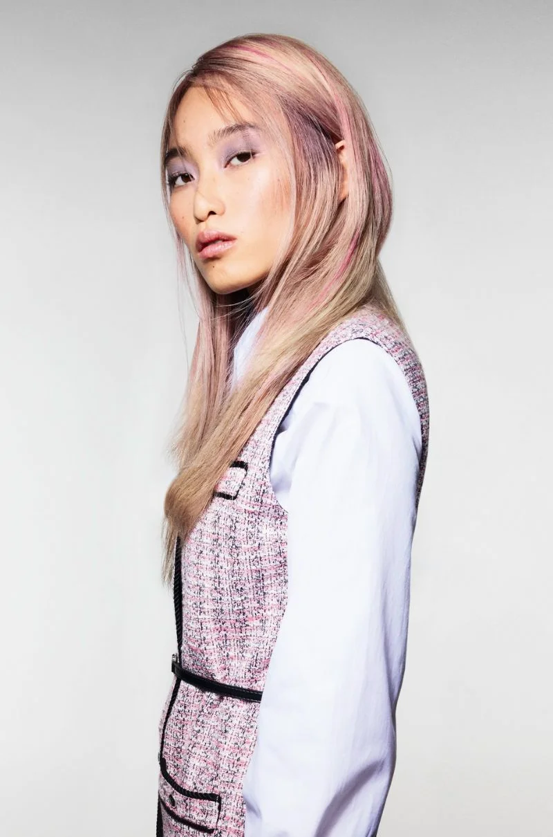 Model met lang blond haar en zachte pastelroze kleuraccenten