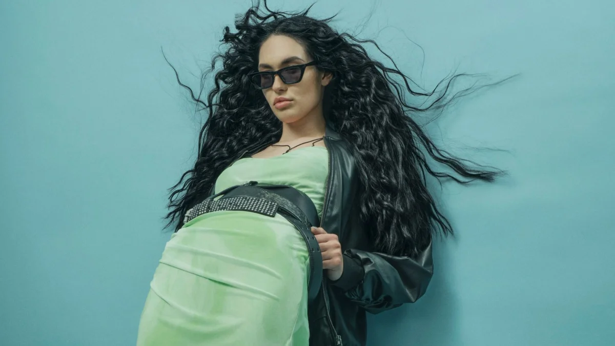 Model met lang zwart krullend haar dat los in beweging valt