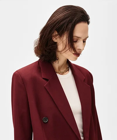 Vrouw met een moderne halflange bruine bob en een bordeauxrode blazer